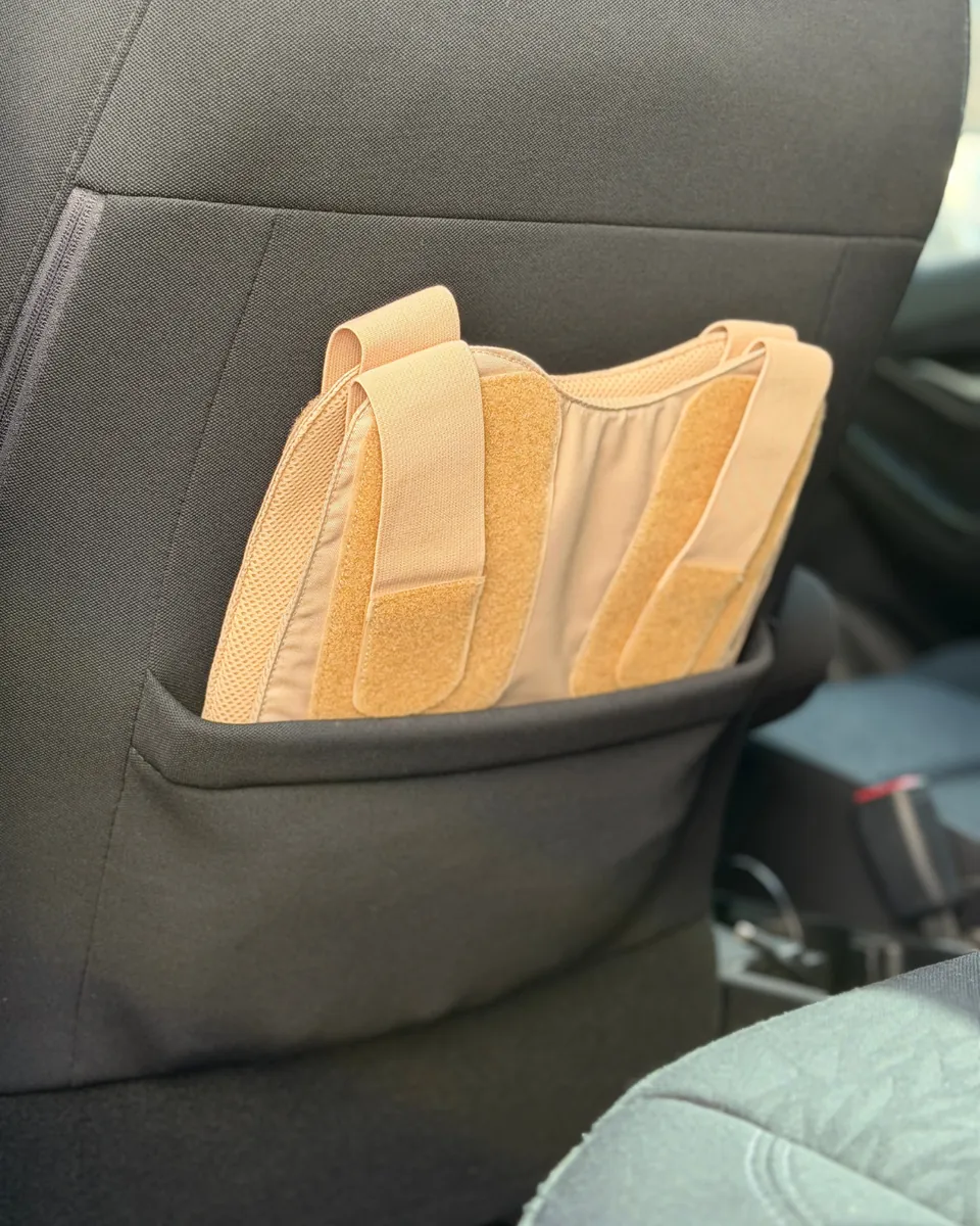 Beige VEP LITE steckt in der Sitztasche hinter einem Autositz